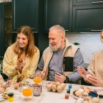 A joyful family bonding over painting Easter eggs in the kitchen, enjoying quality time.